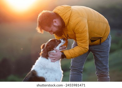 Man in nature with his dog, showing affection. - Powered by Shutterstock