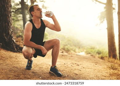 Man, nature and running with break for water or performance, exercise in countryside for wellness. Male runner, workout and stop for recovery with liquid thirst, outdoor for healthy body in Canada - Powered by Shutterstock