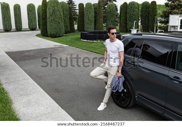 The\
man is near the car. holidays, vacation, love and friendship\
concept - smiling couple having fun on sky\
background