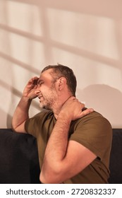 Man with neck, muscle, back and sciatica pain at home.