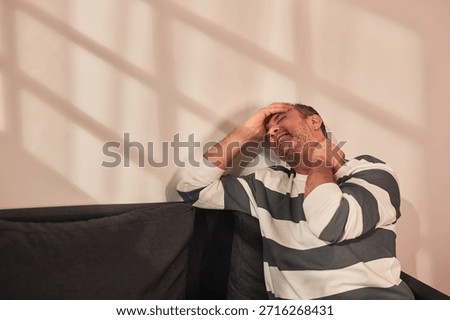 Man with neck, muscle, back and sciatica pain at home.