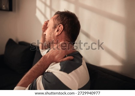 Man with neck, muscle, back and sciatica pain at home.