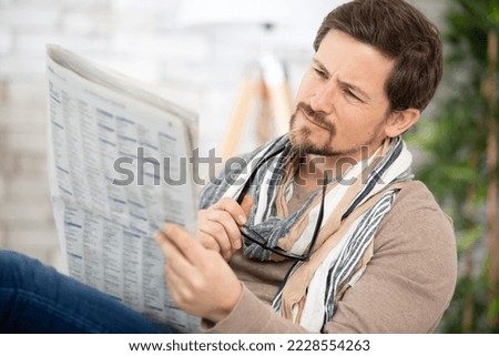 man with newspaper at home