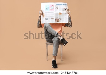 Man with newspaper on beige background