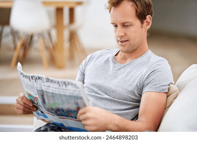 Man, newspaper and relax in home for update, calm and comfortable on weekend in living room. Happy male person, reading and article in apartment, information and rest on couch in pyjamas for story - Powered by Shutterstock