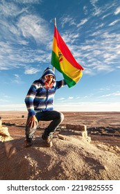 Man Next To Bolivian Flag In Salar De Uyuni