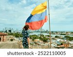 Man next to the flag of Colombia with Cartagena de Indias
