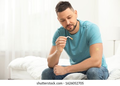 Man With Nicotine Patch And Cigarette In Bedroom