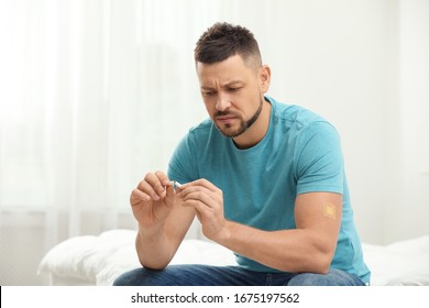 Man With Nicotine Patch And Cigarette In Bedroom