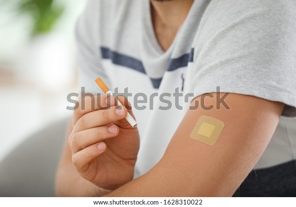 Man with\
nicotine patch and cigarette,\
closeup