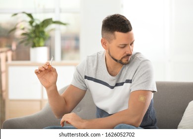 Man With Nicotine Patch And Cigarette At Home