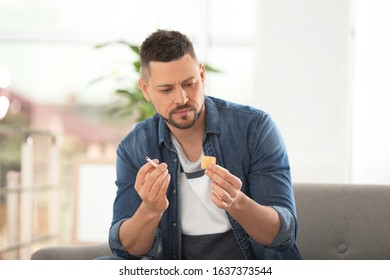 Man With Nicotine Patch And Cigarette At Home