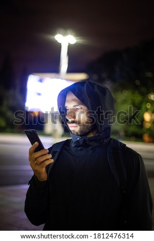 
man in the night city looks at the phone, communication of people