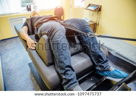 Man at non-surgical spinal decompression procedure in medical center 