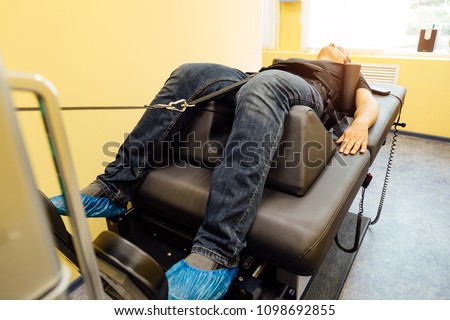 Man at non-surgical spinal decompression procedure in medical center 