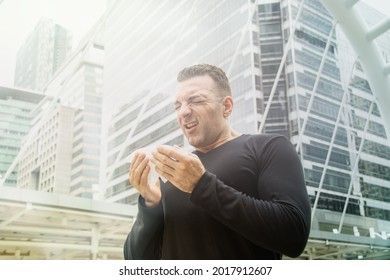 Man Not Wearing A Mask Has Respiratory Problems In A Dusty Environment. Smog, Dense Air Pollution, PM2.5 In The Capital, Has Nasal Irritation, Uses Toilet Paper To Wipe The Nose, Has Allergy Problems.