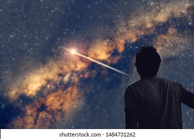 Homem observando o céu noturno e a Via Láctea com uma trilha de estrela cadente. Meu trabalho de astronomia.