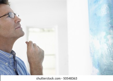 Man Observing Painting In Art Gallery