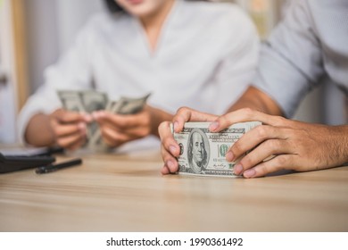 Man offering batch of hundred dollar bills. Hands close up. Venality, bribe, corruption concept. Hand giving money - United States Dollars (or USD). man counting money at the table.