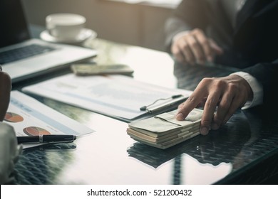 Man offering batch of hundred dollar bills. Hands close up. Venality, bribe, corruption concept. Hand giving money - United States Dollars (or USD). Hand receiving money from businessman. - Shutterstock ID 521200432