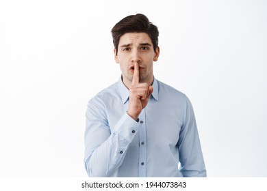 Man Office Worker Shushing, Asking To Keep Quiet, Press Finger To Lips, Shhh Gesture, Standing Over White Background