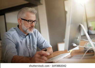 Man In Office Working On Desktop Computer