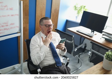 A Man In The Office Yawns At His Workplace. Procrastination.