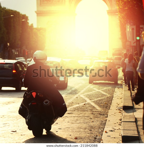 man\
on bike rides in Paris on road in morning at\
sunrise