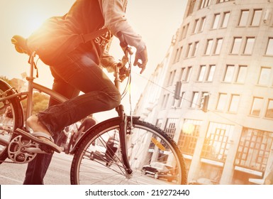 Man on bike in traffic with sunflare 