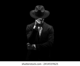 Man on a black background in a suit and hat