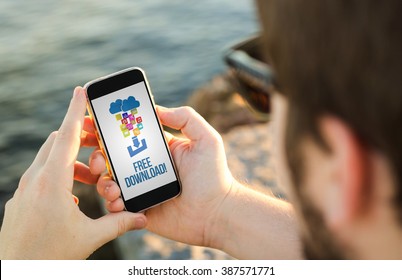 Man On The Coast Using His Smartphone To Free Download. All Screen Graphics Are Made Up.