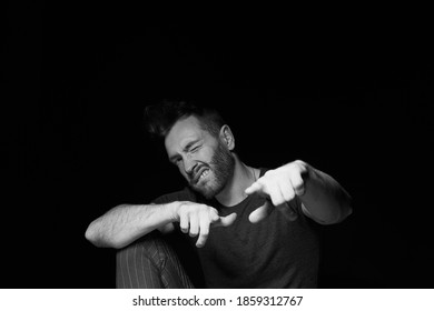 A man on a dark background.A cheeky pose. You deserve it. - Shutterstock ID 1859312767