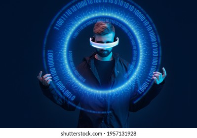 Man on dark virtual reality background. Guy using VR helmet. Augmented reality, future technology, game concept. Blue neon light. Futuristic holographic interface to display data.