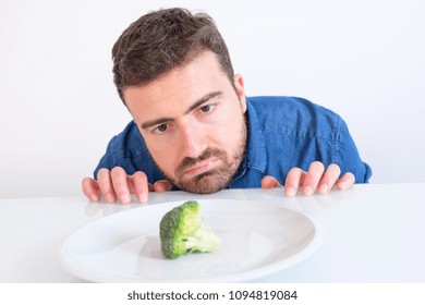 Man On Diet Feeling Hungry And Bored By Vegetable Meal