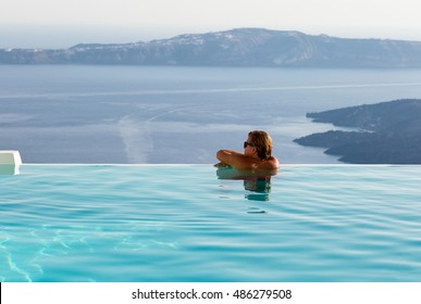 Man On The Edge Of An Infinity Pool Watching The Scenery