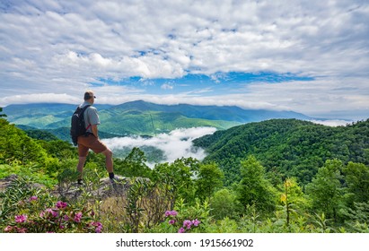 Man On Hiking Trip, Standing On Top Of The Mountain Over The Clouds, Enjoying Beautiful Summer Mountain Scenery. Hiker Looking At Beautiful View. Blue Ridge Mountains, North Carolina, USA.