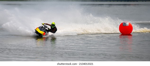 Man On Jet Ski Having Fun In The River With Fast Speed Creating At Lot Of Spray.Jet Ski Turn Around And Speed With Water Splash.