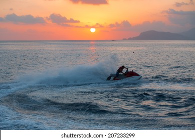 A Man On Jet Ski Jump On The Wave At Amazig Sunset 