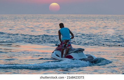 A Man On Jet Ski Jump On The Wave At Amazig Sunset 