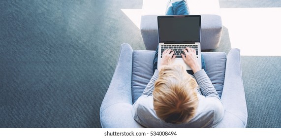 Man on a laptop in a modern brightly lit room - Shutterstock ID 534008494