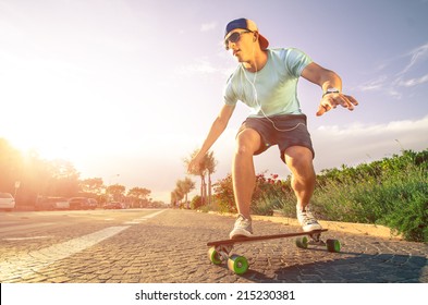 Man On Longboard Skate At Sunset