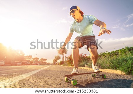 Man on longboard skate at sunset
