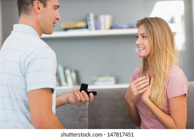 Man On One Knee Proposing To Girlfriend In Sitting Room At Home