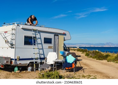 Man On Roof Of Caravan. Repair Rv Motor Home. Holidays Trip.