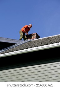 Man on the roof of his house inspecting his chimney