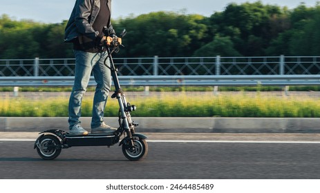 A man on a scooter is driving fast on the road