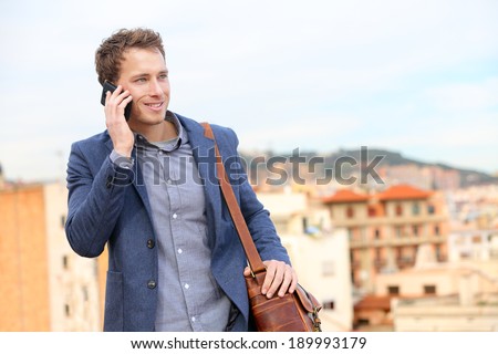 Man on smartphone - young business man talking on smart phone. Casual urban professional businessman using mobile cell phone smiling happy walking. Handsome man wearing suit jacket in Barcelona, Spain