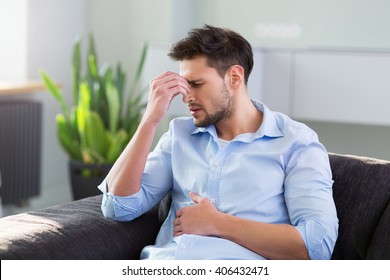 Man On Sofa Having Headache - Shutterstock ID 406432471
