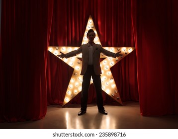 Man On Stage With Star On Background