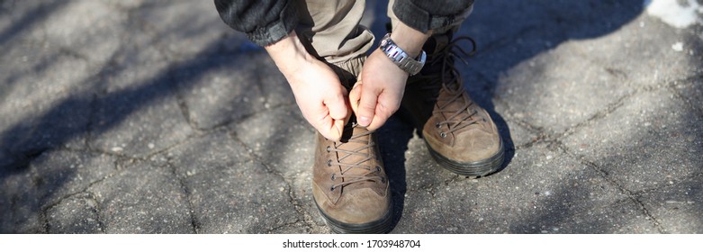 Man On Street Leaned Over And Tied Shoelaces. Walk In Park During Quarantine. Fresh Air Activates Bodys Defenses. Pandemic Breach Emergency. Guy In Casual Clothes Is Standing On Pavement